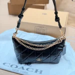 This underarm bag features shiny cowhide leather, in a classic black colorway with a metal chain-box - Image 8