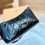 This underarm bag features shiny cowhide leather, in a classic black colorway with a metal chain-box - Image 7