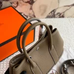 "Garden bag crafted from full-grain Togo cowhide, featuring a soft texture. Equipped with steel hardware, hand-stitched wrist strap, and original lining-box - Image 5