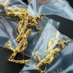 YSL Gold tone Cassandre Metal Brooch, Vintage Twisted Logo Pin, Blazer & Coat Accessory - Image 6