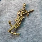 YSL Gold tone Cassandre Metal Brooch, Vintage Twisted Logo Pin, Blazer & Coat Accessory - Image 8